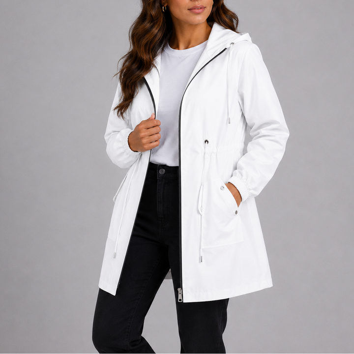 A woman wears an open white hooded parka jacket with drawstring waist over a white t-shirt and black jeans.