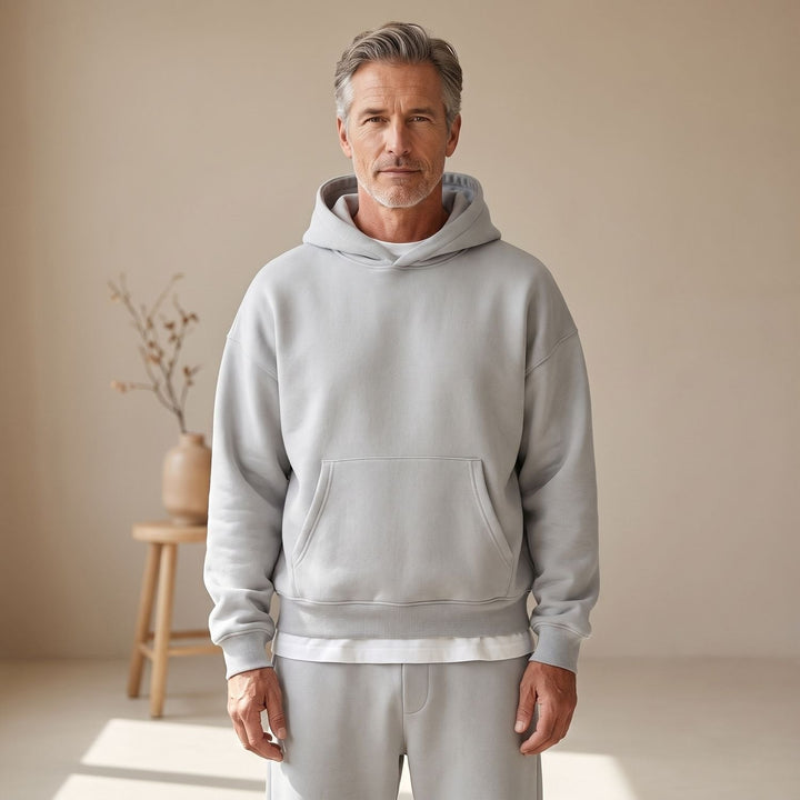Man wearing light gray hooded sweatshirt with matching joggers, worn casually | Grace Aura