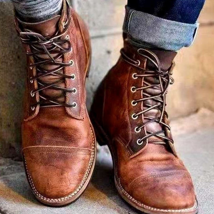 Brown lace-up ankle boots worn by person, cuffed jeans visible | Grace Aura