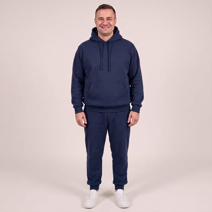 Man wearing navy hoodie and matching jogger sweatpants, front view, standing | Grace Aura