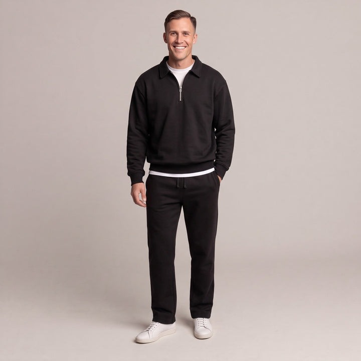 Man wearing black quarter-zip sweatshirt with matching joggers and white sneakers | Grace Aura