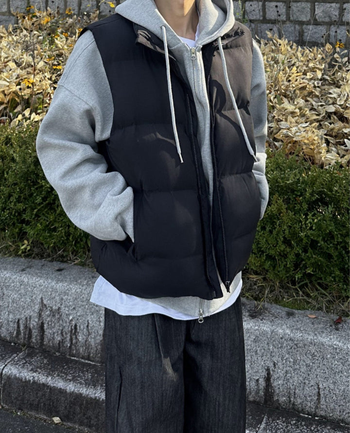 Black padded puffer gilet for men worn over a grey hoodie