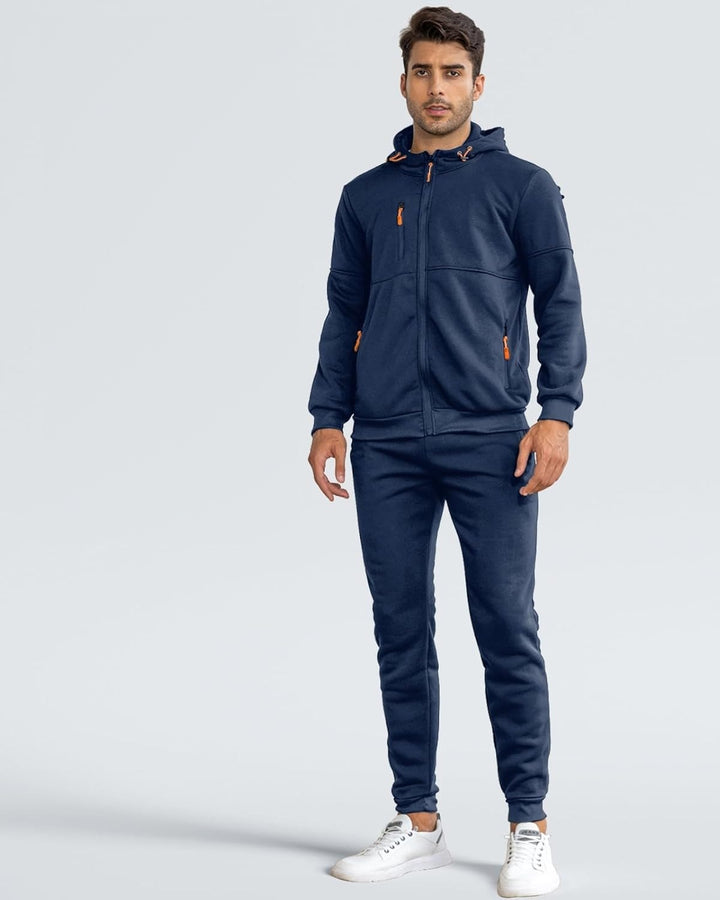 Man in a navy zip hoodie and joggers tracksuit, front view