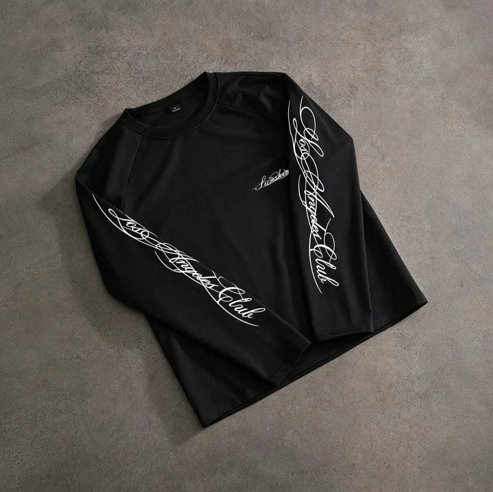 Black long sleeve t-shirt with script print, laid flat on surface | Grace Aura