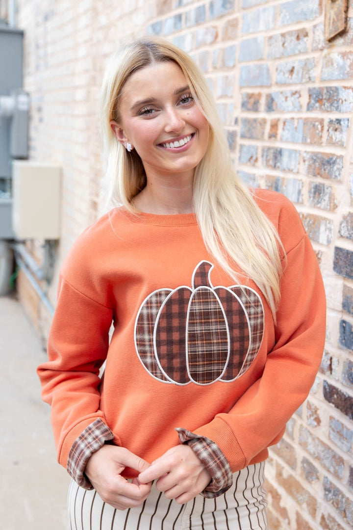 Orange sweatshirt with a plaid pumpkin appliqué