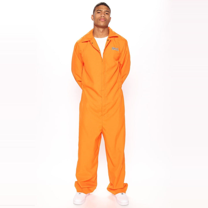 Man wearing orange jumpsuit costume with white sneakers, standing against plain background | Grace Aura