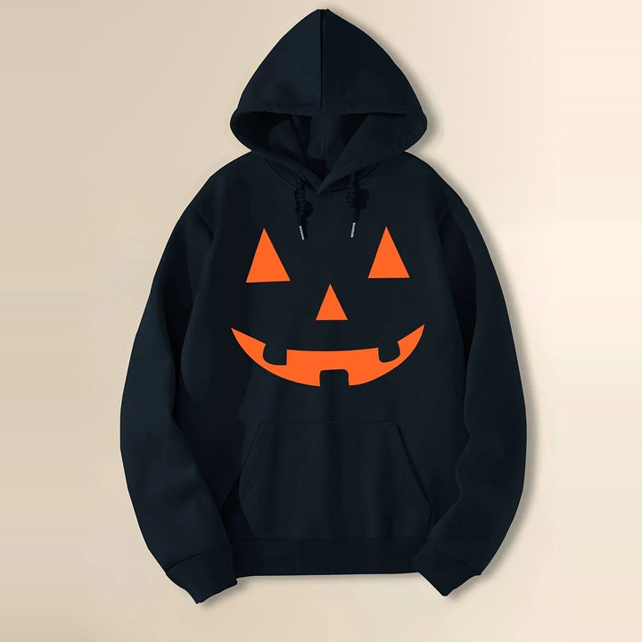 Black hoodie with orange jack-o-lantern face print, hung flat against beige background | Grace Aura