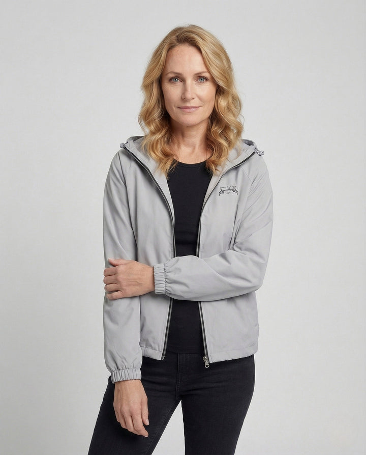 Woman wearing gray hooded zip-up jacket with black top and jeans | Grace Aura