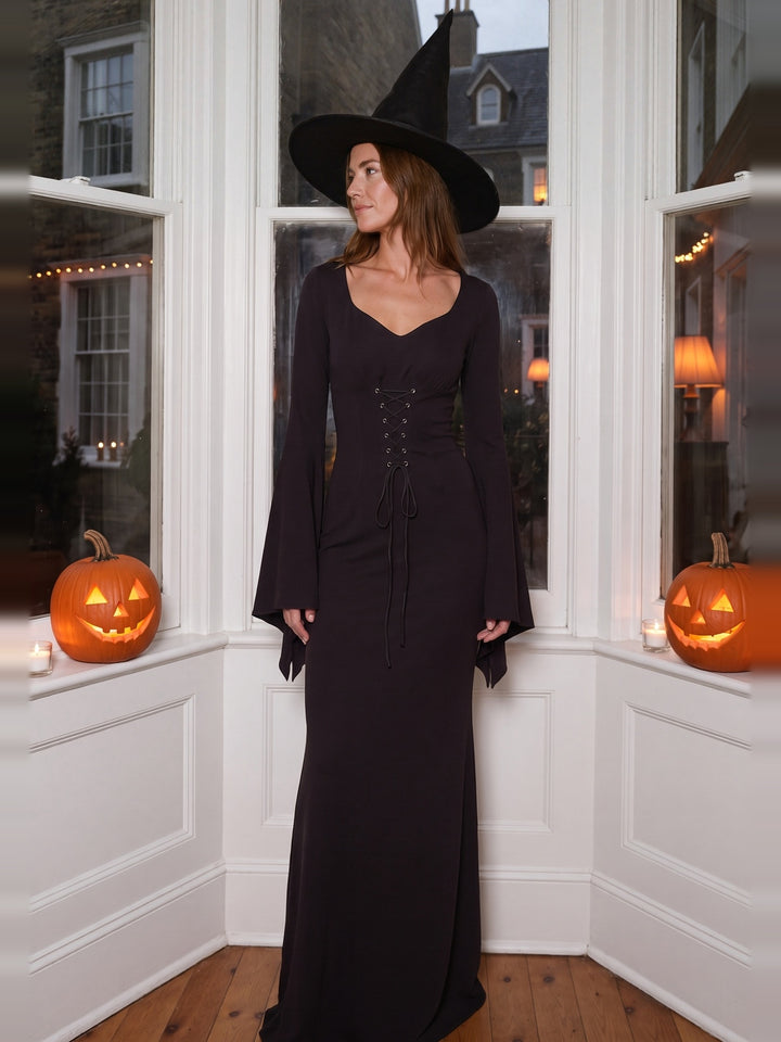 Woman in a long black witch costume dress and pointed hat