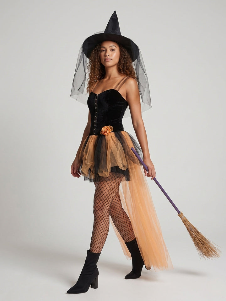 Woman in a velvet witch costume with orange tulle skirt and hat with veil