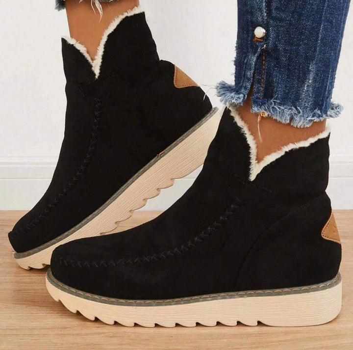 Black suede fur-lined ankle boots worn on feet with skinny jeans | Grace Aura