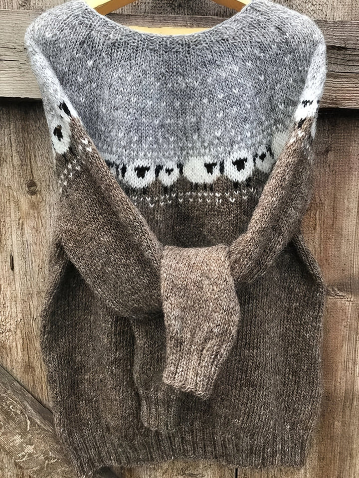 Grey and brown chunky knit jumper with a sheep pattern on the yoke, on a hanger