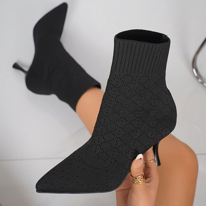 Black knitted sock boots with a stiletto heel on the foot