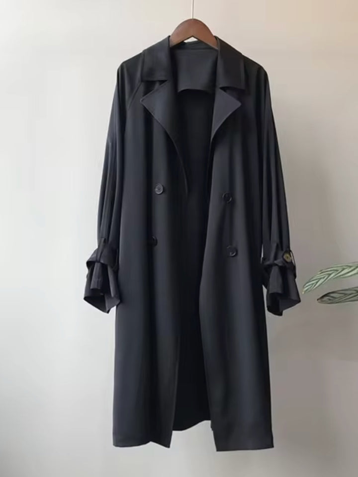 Black long double-breasted trench coat on a hanger