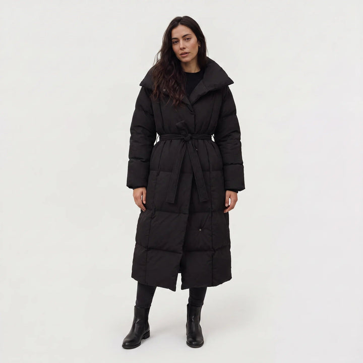 Woman in a long black belted puffer coat, front view
