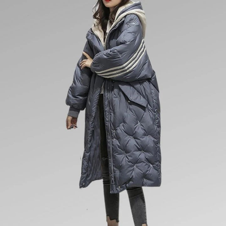 Woman wearing gray oversized long puffer coat with striped hood trim | Grace Aura