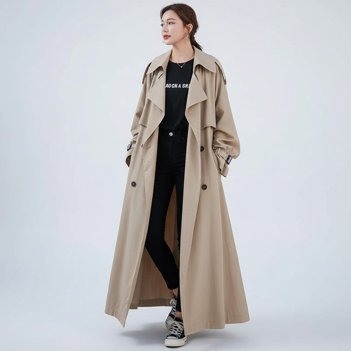 Woman in a long beige oversized trench coat, hands in pockets