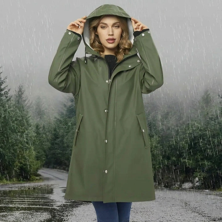 Green long waterproof raincoat with hood, worn outdoors in the rain