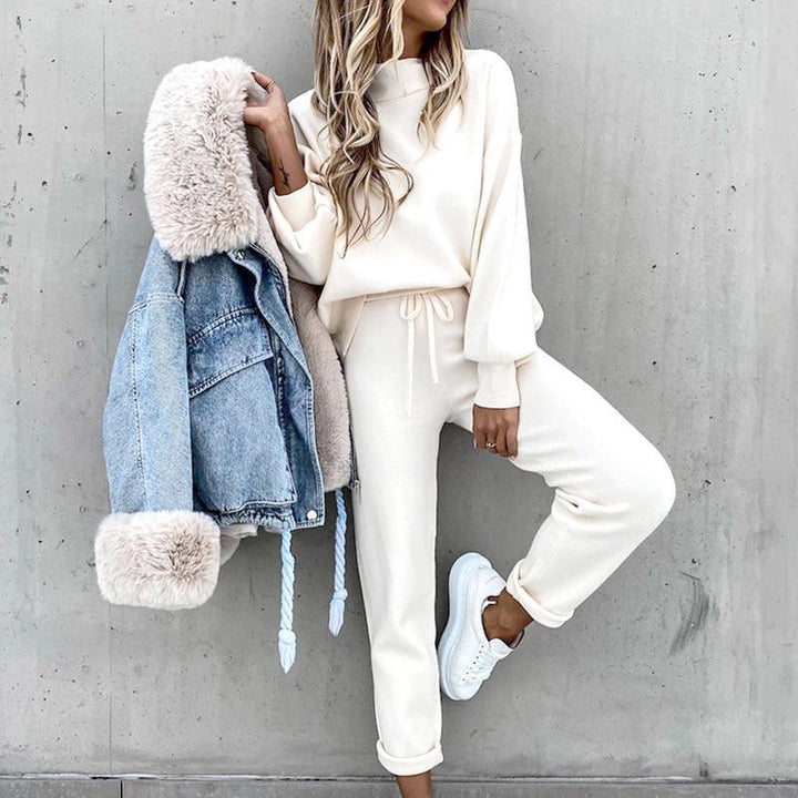 Woman wearing cream knitted loungewear set with high neck, holding denim jacket | Grace Aura