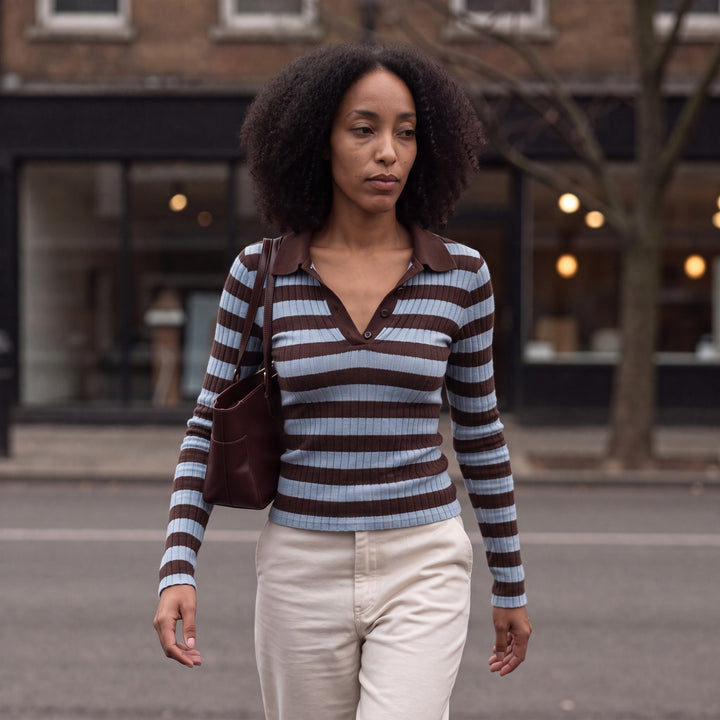 Woman wearing the Brown/Light Blue striped polo knit jumper