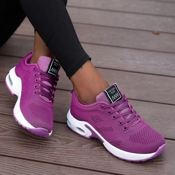 Purple knit sneakers with white air cushion sole, worn by person | Grace Aura